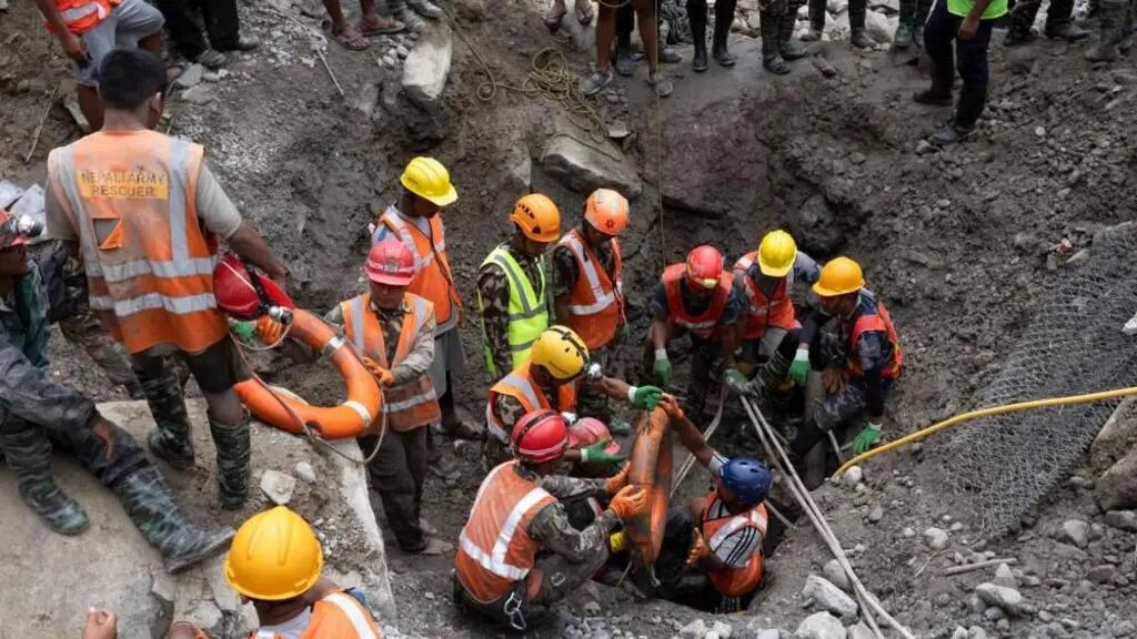 Emergency rescue workers searching through flood debris in Nepal